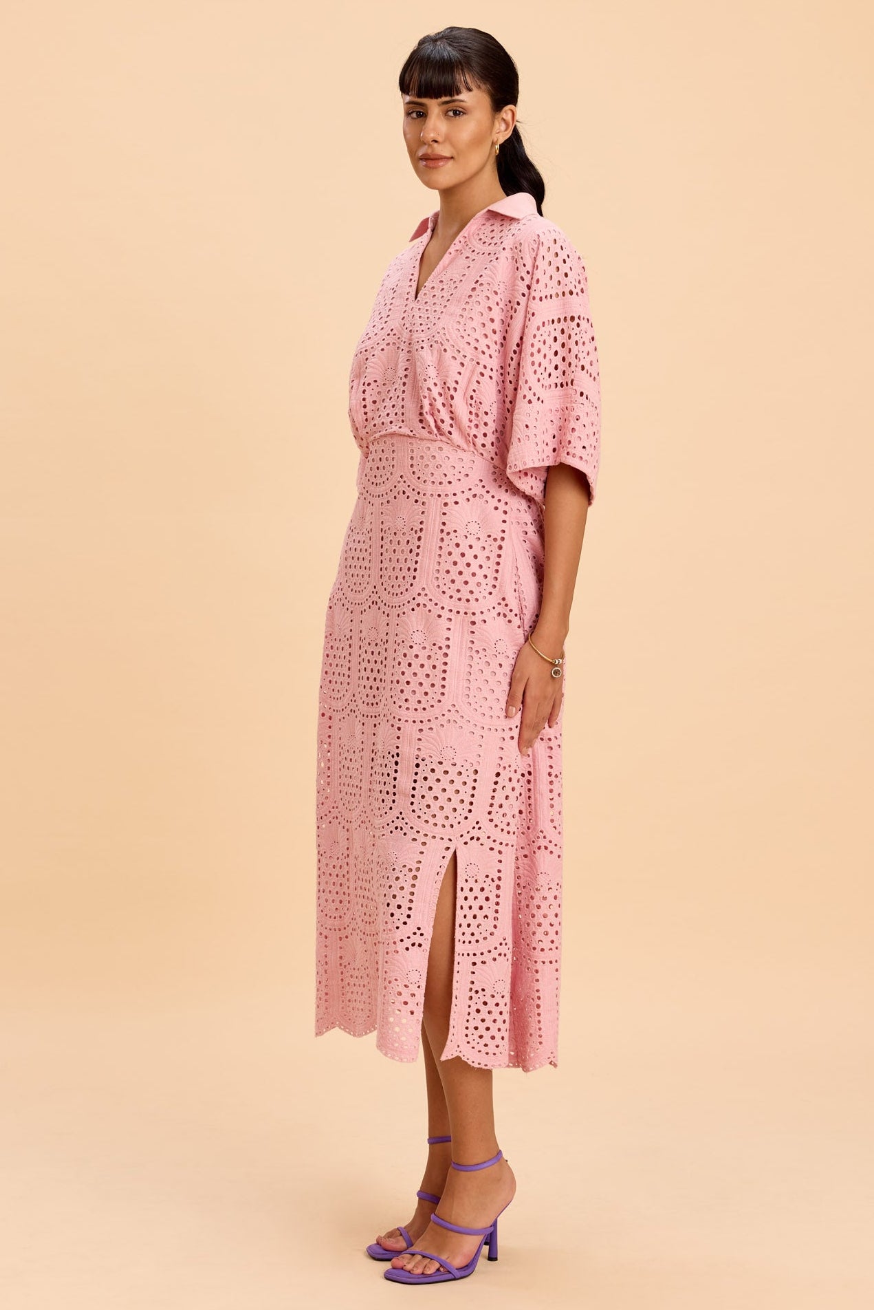 Woman wearing a pink dress against a beige background