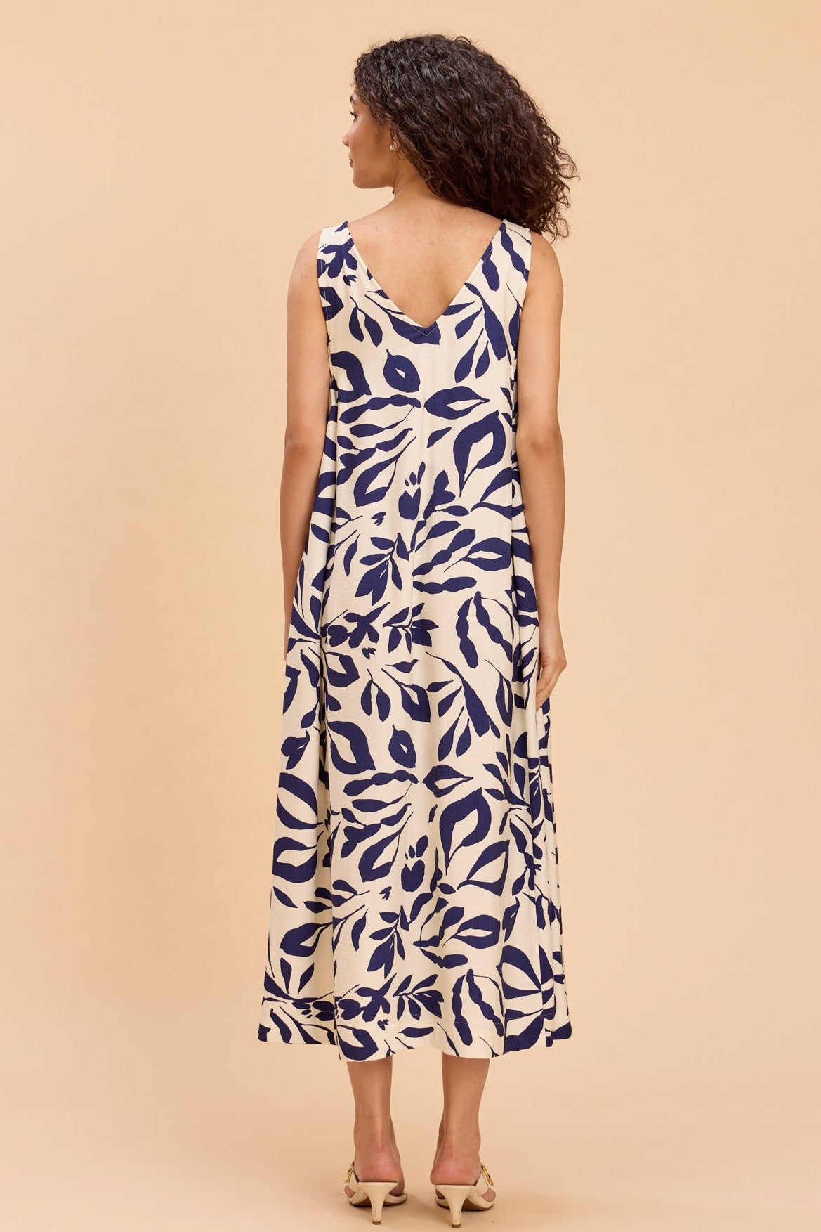 Woman wearing a floral dress against a beige background