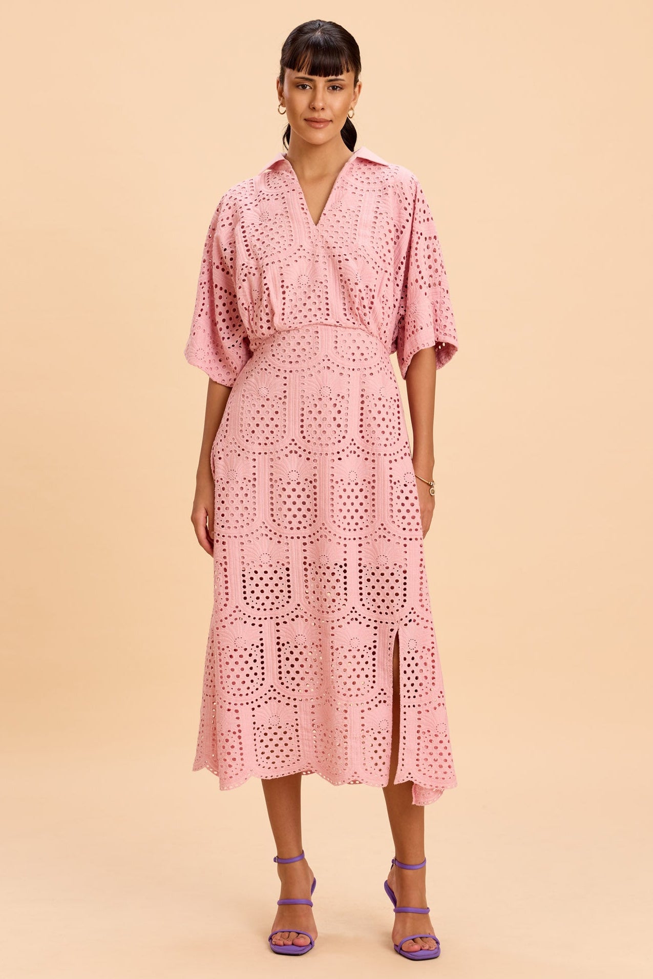 Woman wearing a pink lace dress on a beige background