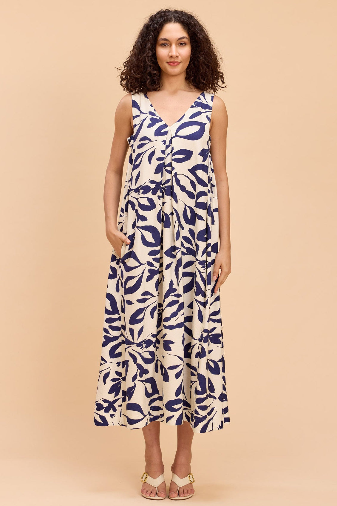 Woman wearing a blue and white patterned dress on a beige background