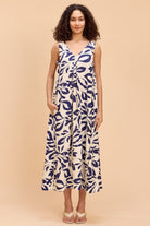 Woman wearing a blue and white patterned dress on a beige background