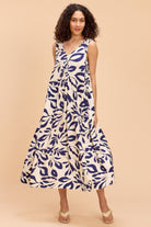 Woman wearing a blue and white patterned dress on a beige background